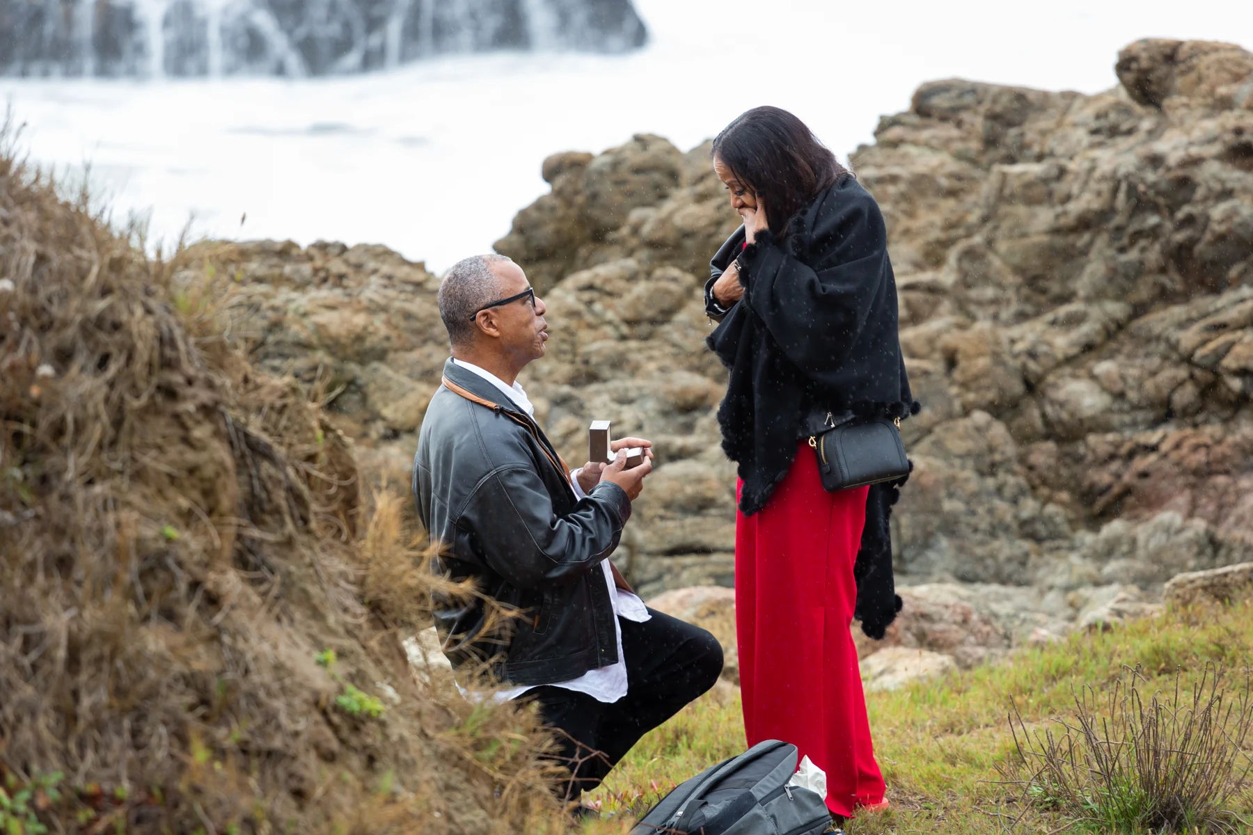 Ken proposing to Angela by the ocean
