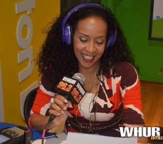 Angela at WHUR wearing headphones and holding a microphone